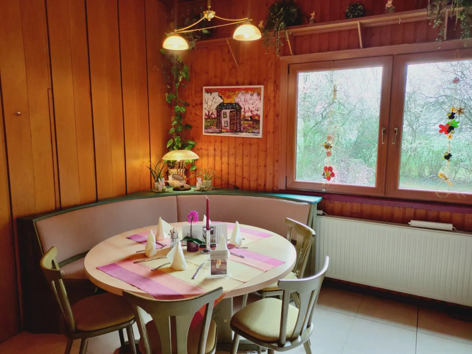 Runder gedeckter Tisch mit Eckbank am Fenster