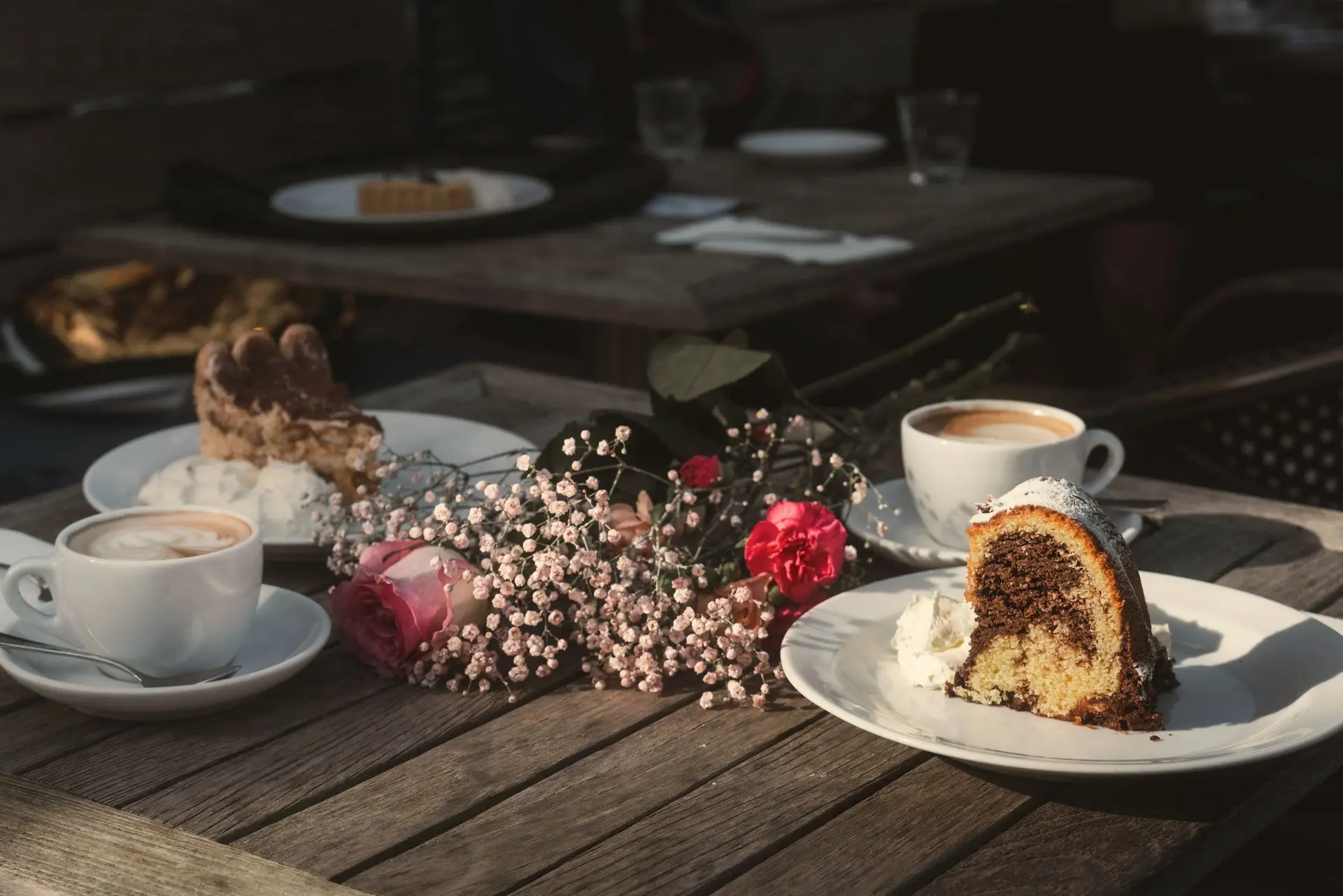 Gedeckter Kaffeetisch mit Kuchen und Blumen